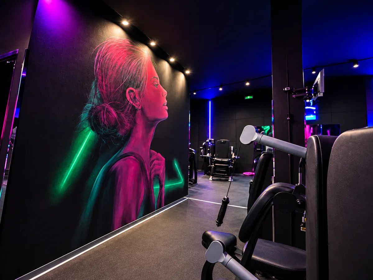 Il murale al neon di Girl Power accanto alle macchine